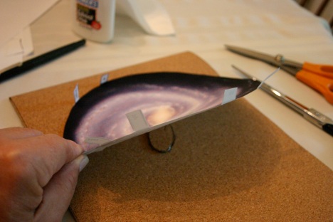 As you glue the image to the base, bend the tabs up out of the way - and, of course, be sure to position this so the yellow galaxy core is over the raised area - aside fromthat there is nothing crucial about the positioning. 